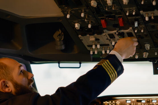 airplane captain starting engine with power buttons dashboard fly plane from cockpit pushing switch lever takeoff using control panel command with windscreen compass