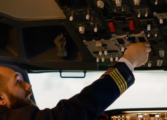 airplane captain starting engine with power buttons dashboard fly plane from cockpit pushing switch lever takeoff using control panel command with windscreen compass