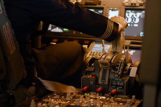Boeing 777 Safety: Exploring Its Key Features 77 aviation crew flying airplane with engine lever throttle using dashboard command buttons takeoff control panel navigantion windscreen fly plane using power handle close up